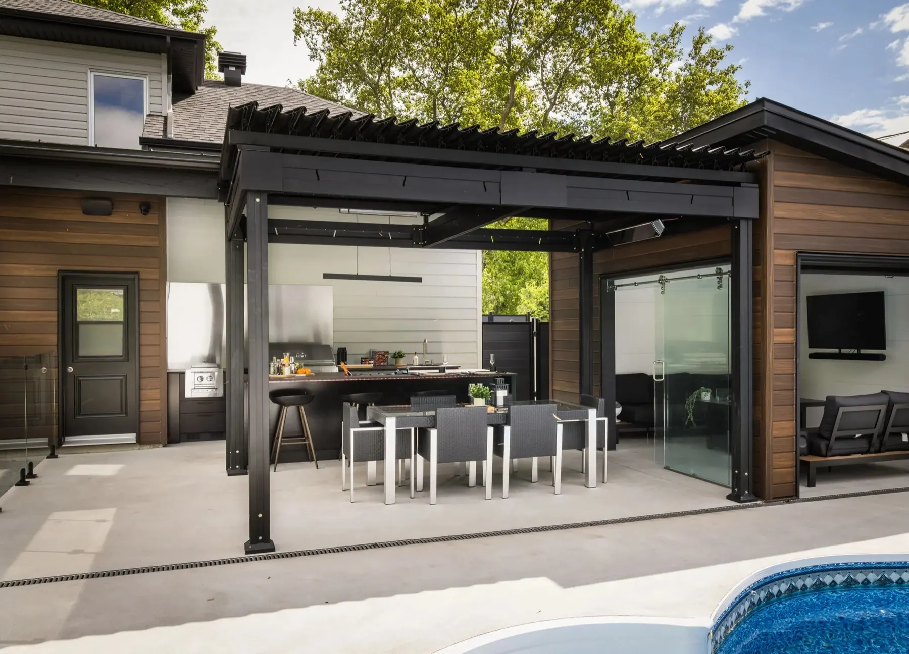 Two runs and a pool — the full outdoor kitchen seen from the yard